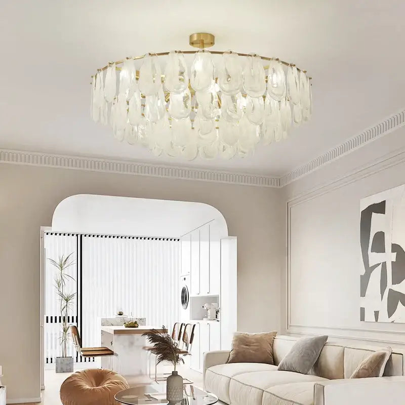 A modern decorbites crystal chandelier with a gold-toned frame and white glass teardrop shades for living room use
