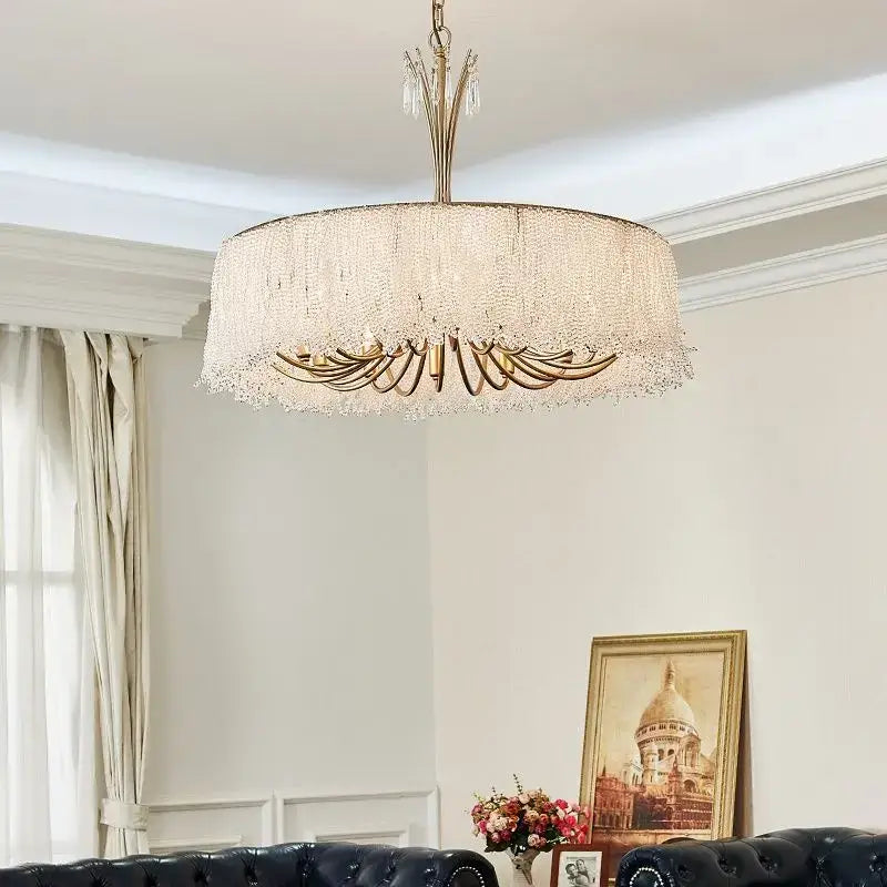A luxurious gold-toned decorbites crystal chandelier with cascading crystal fringe and multiple light fixtures for villa halls