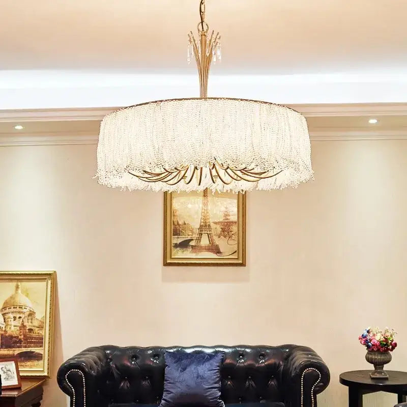 A luxurious gold-toned decorbites crystal chandelier with cascading crystal fringe for villa hall and bedroom lighting