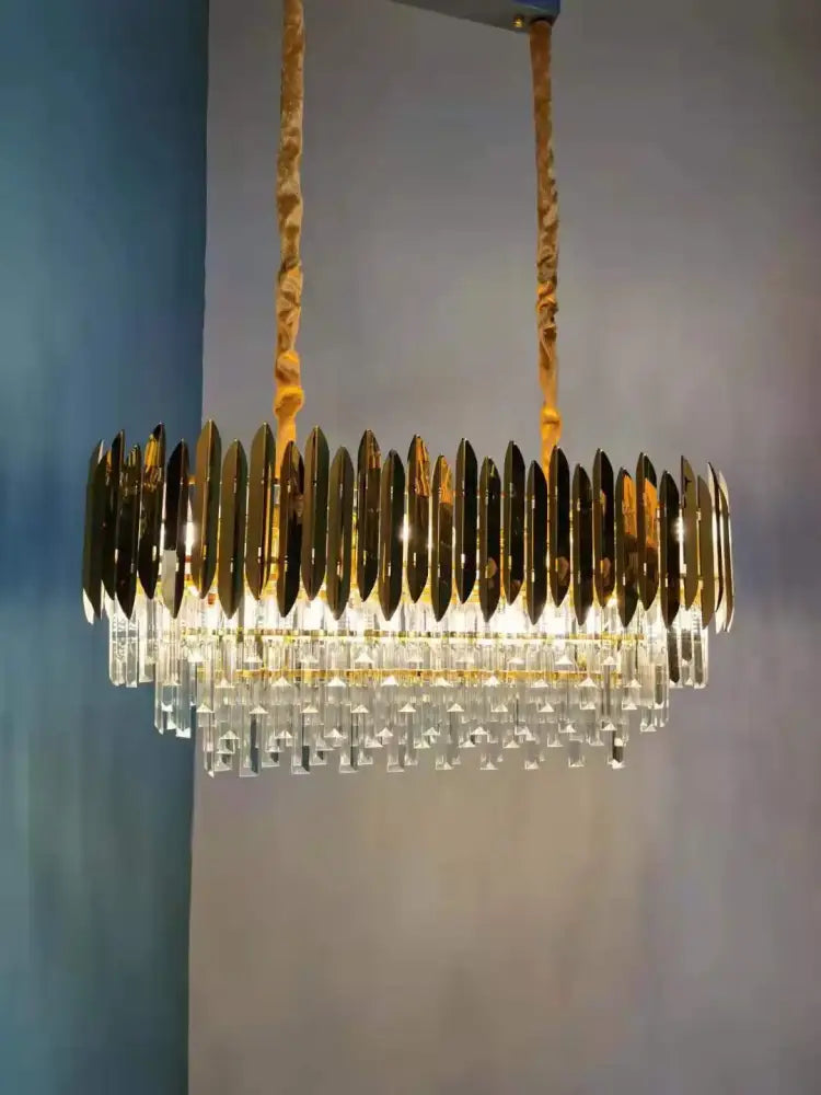 Gold-toned decorbites crystal chandelier with circular metallic blades and clear crystal droplets for modern dining room lighting