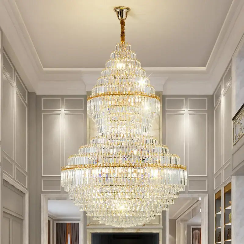 A multi-tiered decorbites crystal chandelier with gold-toned metal and clear faceted crystals for modern loft lighting