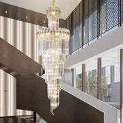 A decorbites crystal chandelier with gold accents and cascading prisms in a modern duplex villa hall lighting