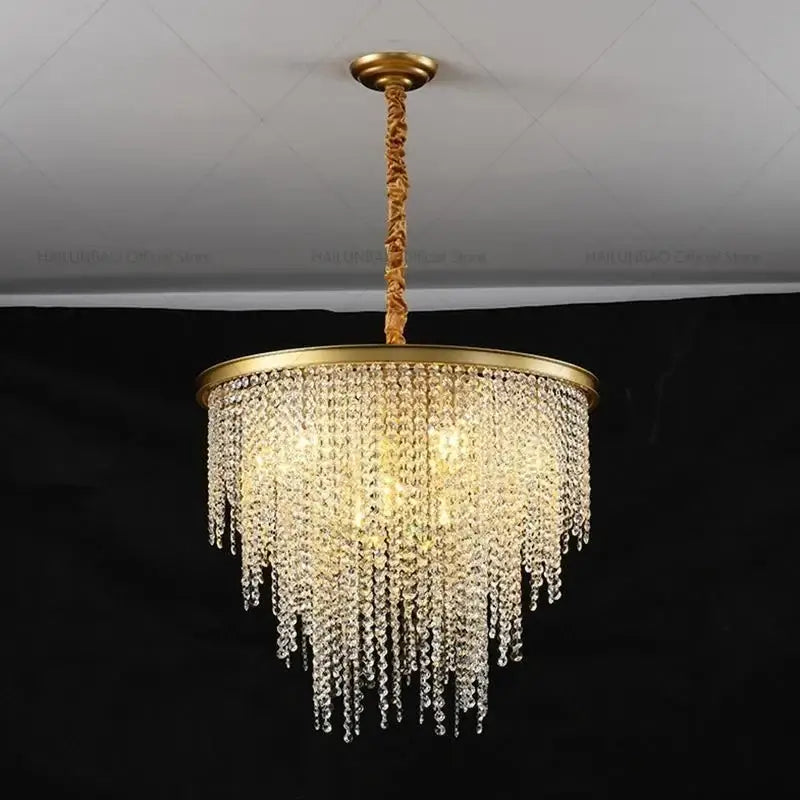 Gold-toned decorbites crystal chandelier with cascading clear crystal droplets and circular brass frame pendant light