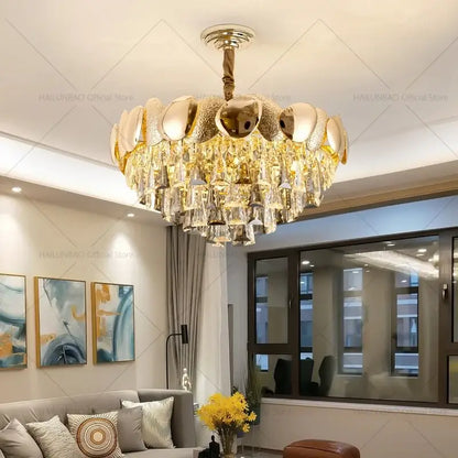 Gold-toned decorbites crystal chandelier with tiered design featuring metallic orbs and cascading crystal droplets for elegant spaces