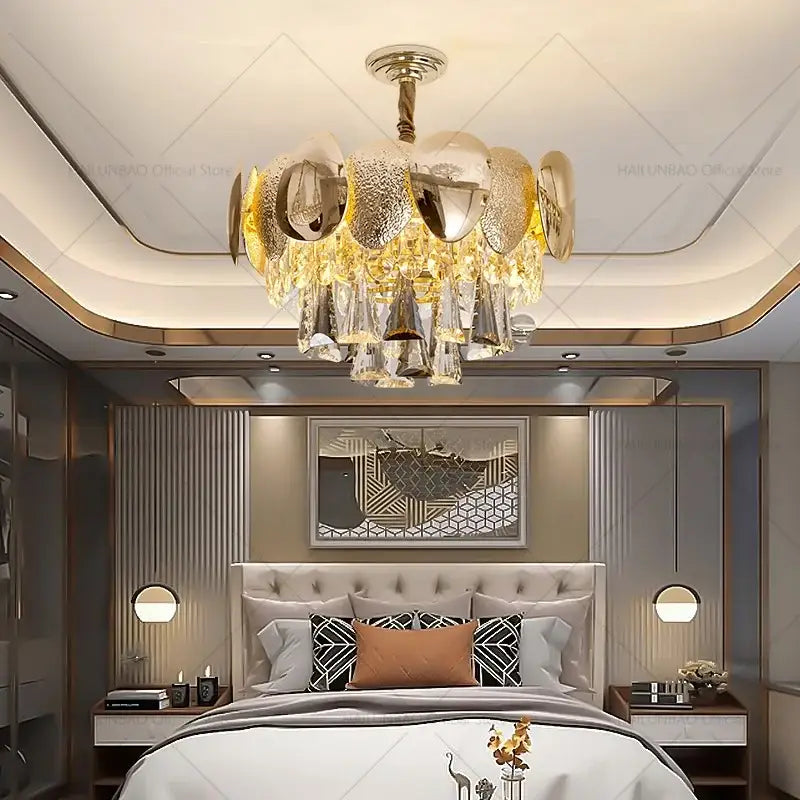 Gold and clear crystal DecorBites crystal chandelier with modern layered design hanging above the bed