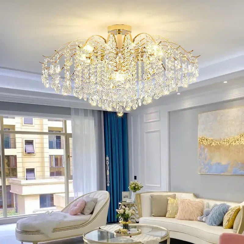 A luxurious gold-toned decorbites crystal chandelier with cascading crystal droplets and intricate branching arms