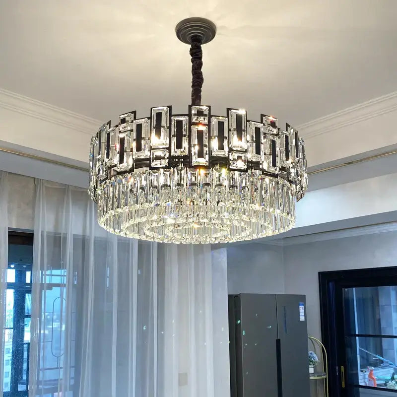 A decorbites crystal chandelier with a dark metal frame, rectangular crystal panels, and cascading clear glass prisms