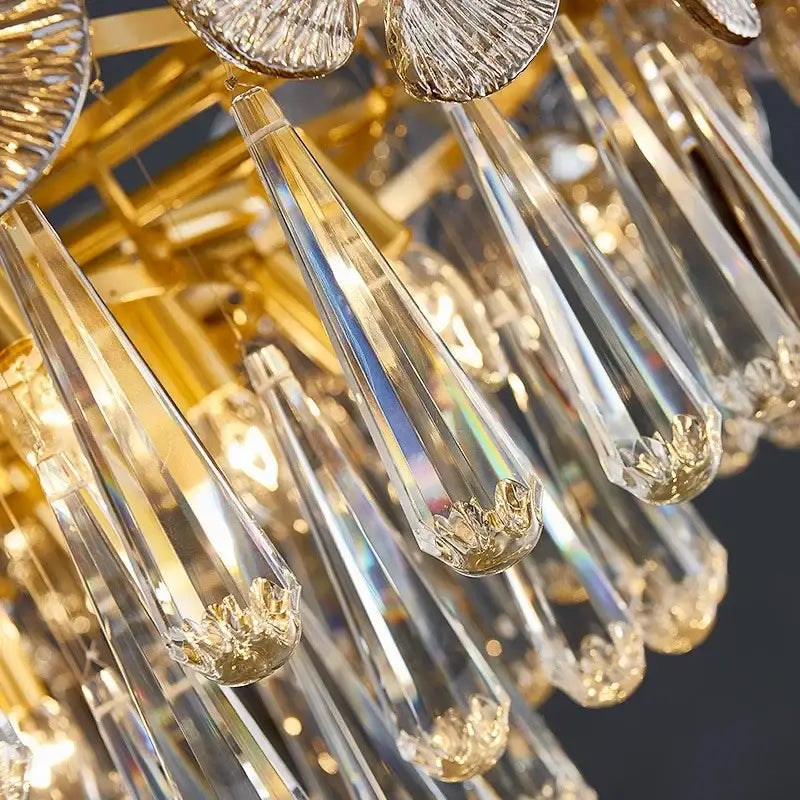 Golden-framed decorbites crystal chandelier with clear teardrop pendants and ornate gold leaf accents for living spaces