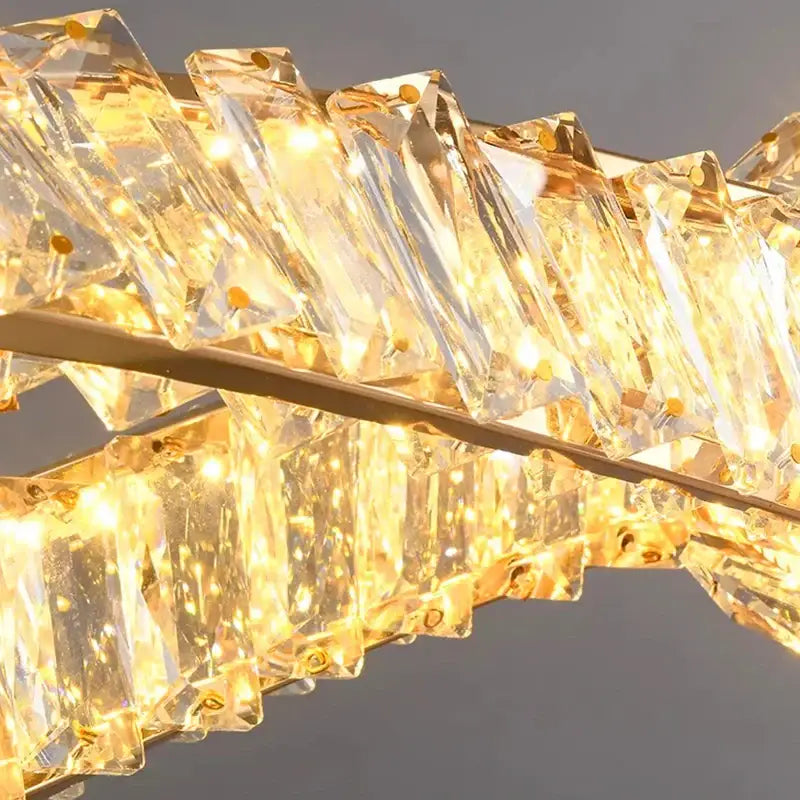 Modern golden-tinted faceted crystal prisms in a curved line form the decorbites crystal chandelier pendant light fixture