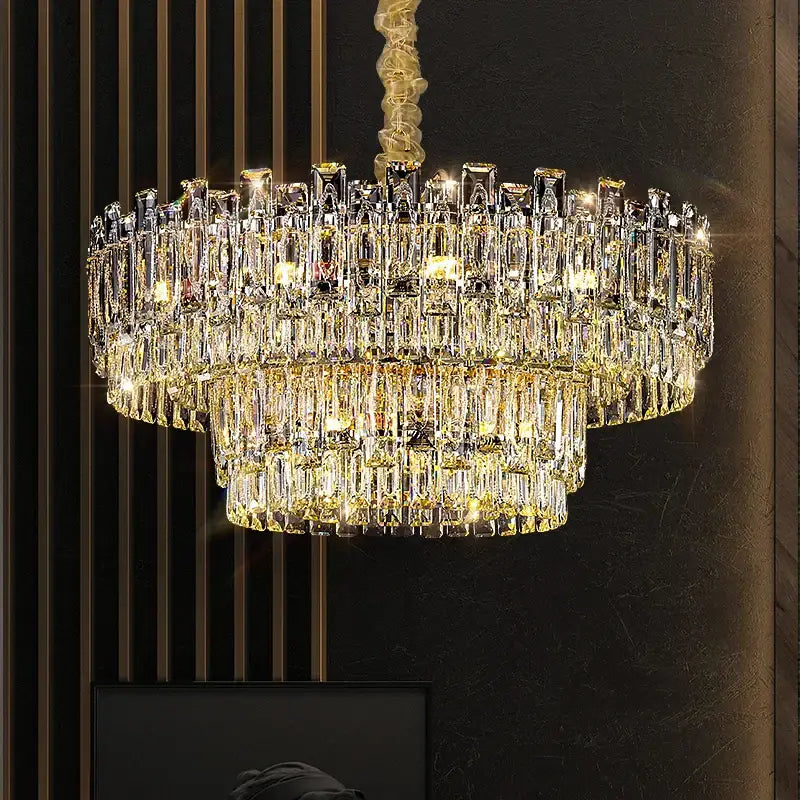 A decorbites crystal chandelier with multi-tiered cascading rectangular prisms illuminated by warm golden lights