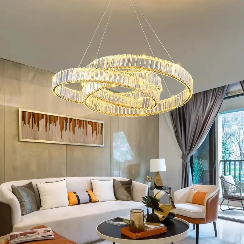 A modern multi-tiered decorbites crystal chandelier with golden rings and clear faceted crystals for home lighting