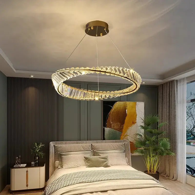 A modern gold-toned circular decorbites crystal chandelier with faceted crystals and embedded led lights for living rooms