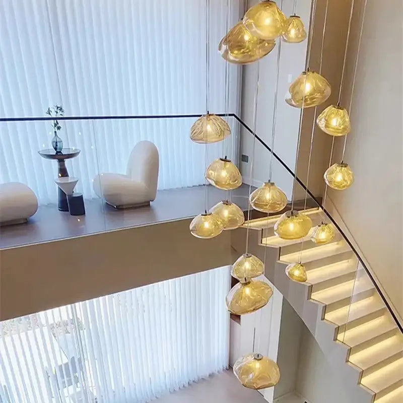 Golden translucent glass pendant lights in a cascading decorbites crystal chandelier for modern stair lighting