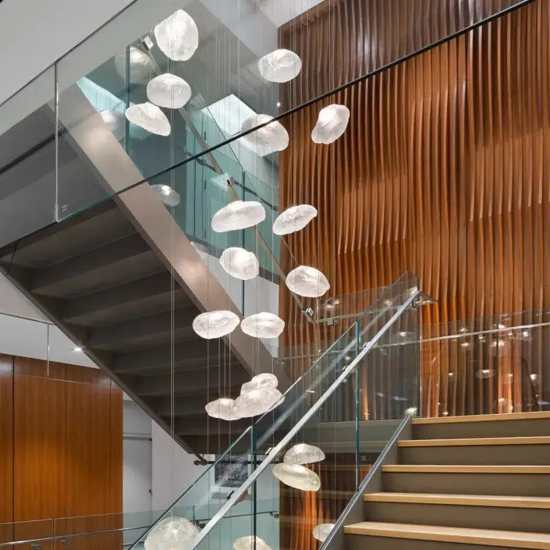 A modern translucent white glass decorbites crystal chandelier with cloud design hangs above staircase lighting interior