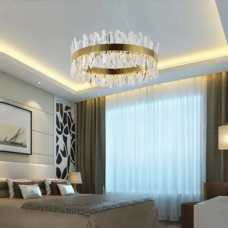A decorbites crystal chandelier with a modern circular gold metal frame and clear hanging crystals for living room lighting