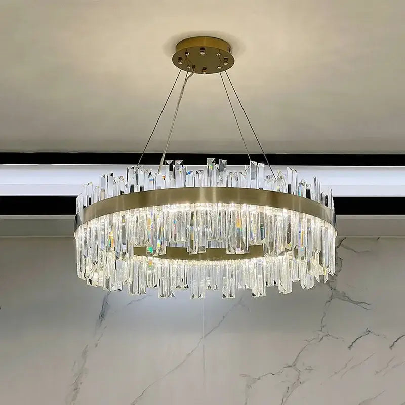A modern brass-finished decorbites crystal chandelier with hanging prisms for living room bedroom kitchen lighting