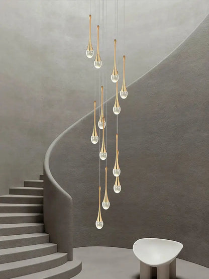 A modern gold-toned decorbites crystal chandelier with clear glass teardrop shades for living room and staircase