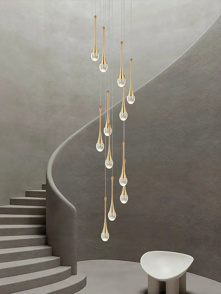 A modern gold-toned decorbites crystal chandelier with clear glass teardrop shades for living room and staircase