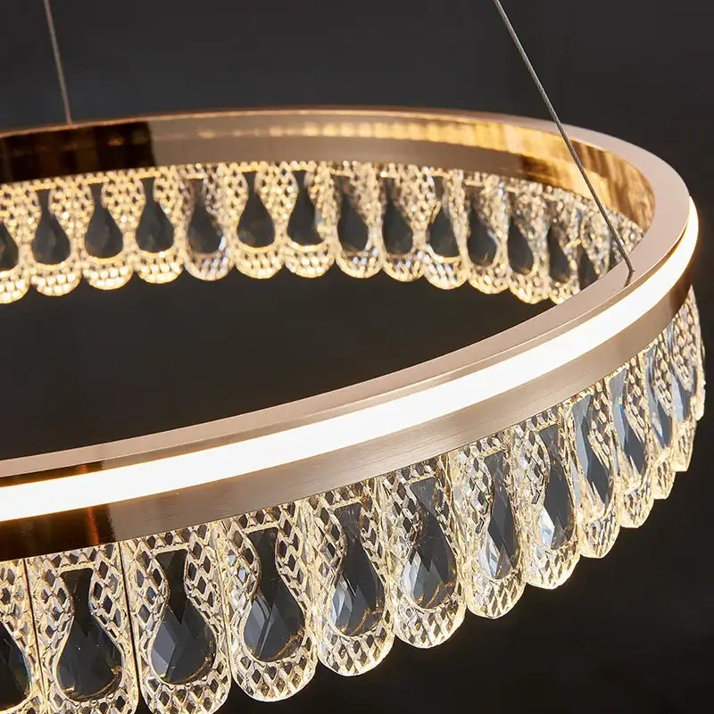 Gold-toned decorbites crystal chandelier with intricate cut crystal droplets for modern luxurious living spaces