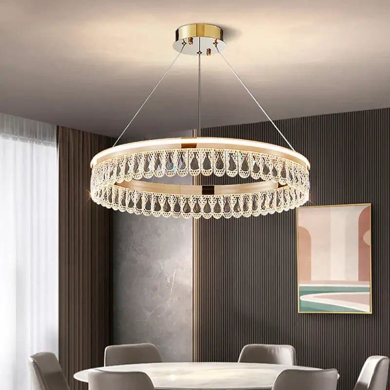 Modern gold-toned decorbites crystal chandelier with dangling crystals for luxurious living and dining rooms