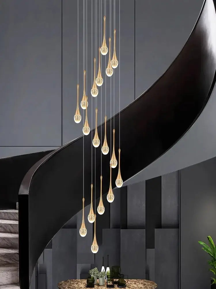 Golden teardrop-shaped decorbites crystal chandelier with crystal accents hanging from modern staircase in villa living room