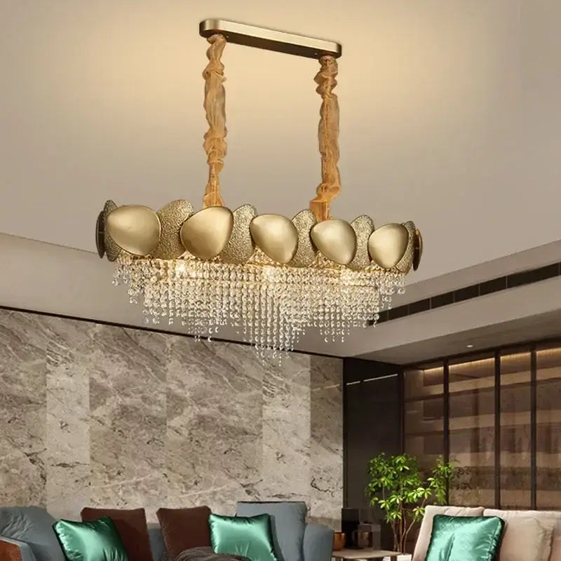 Gold-toned decorbites crystal chandelier with sculptural shell-shaped fixtures and cascading crystal droplets for living room