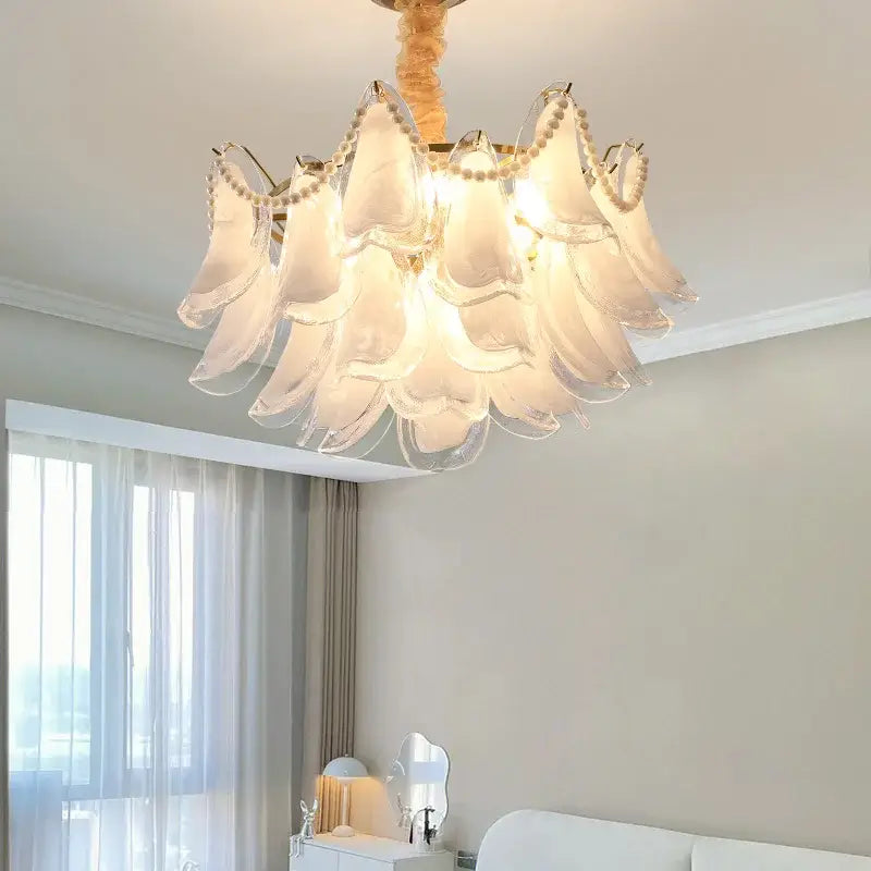 A delicate translucent white glass decorbites crystal chandelier with a golden frame and beads for modern luxury lighting