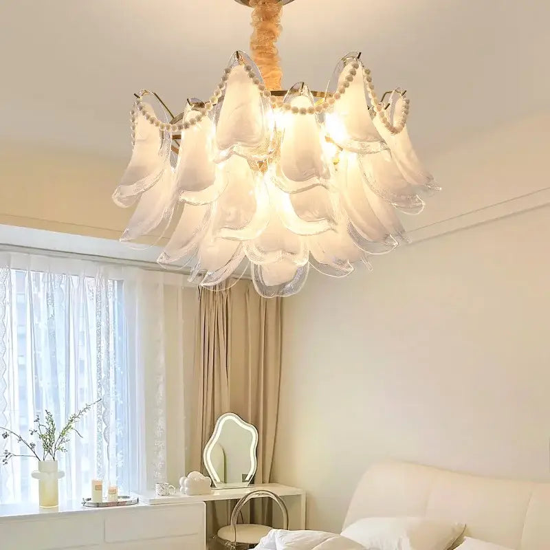 A delicate white glass decorbites crystal chandelier with petal-like shades and pearl accents for modern luxury lighting
