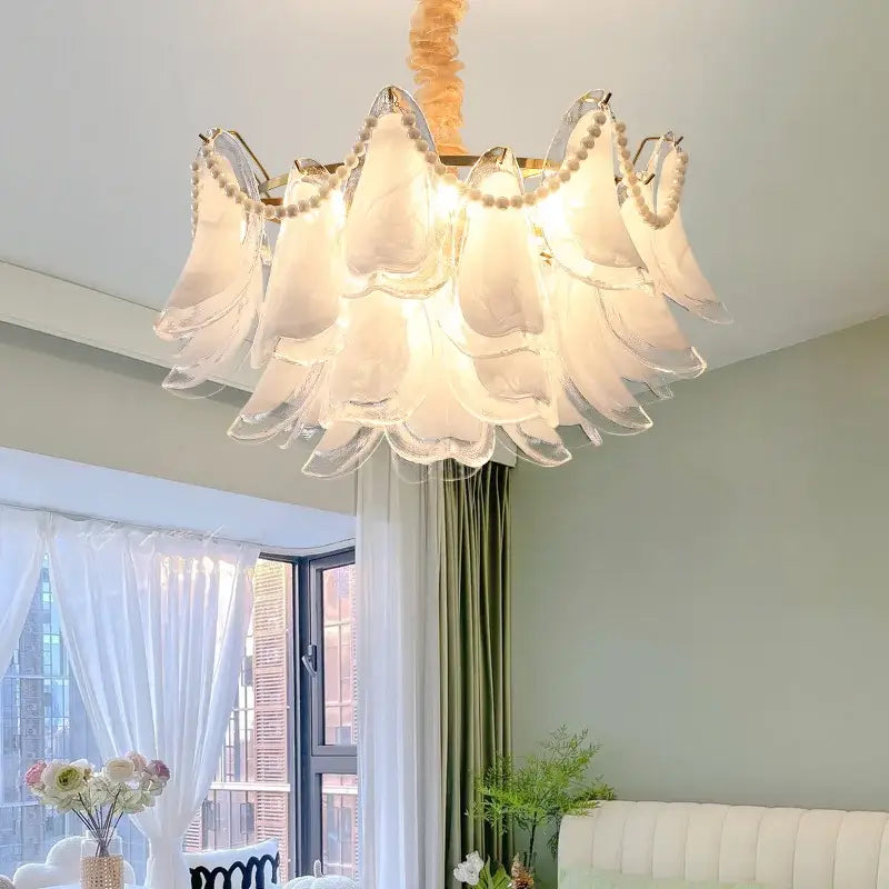 DecorBites crystal chandelier is a delicate white glass with scalloped petals and pearl accents for modern luxury lighting