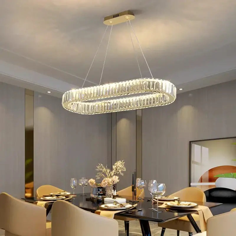 A modern oval-shaped decorbites crystal chandelier with gold-toned mount and clear faceted glass for living room lighting