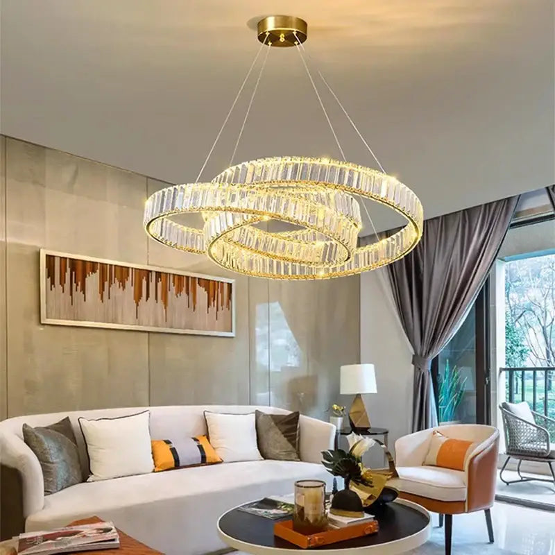 Gold-toned decorbites crystal chandelier with three interlocking crystal rings for modern living and dining rooms