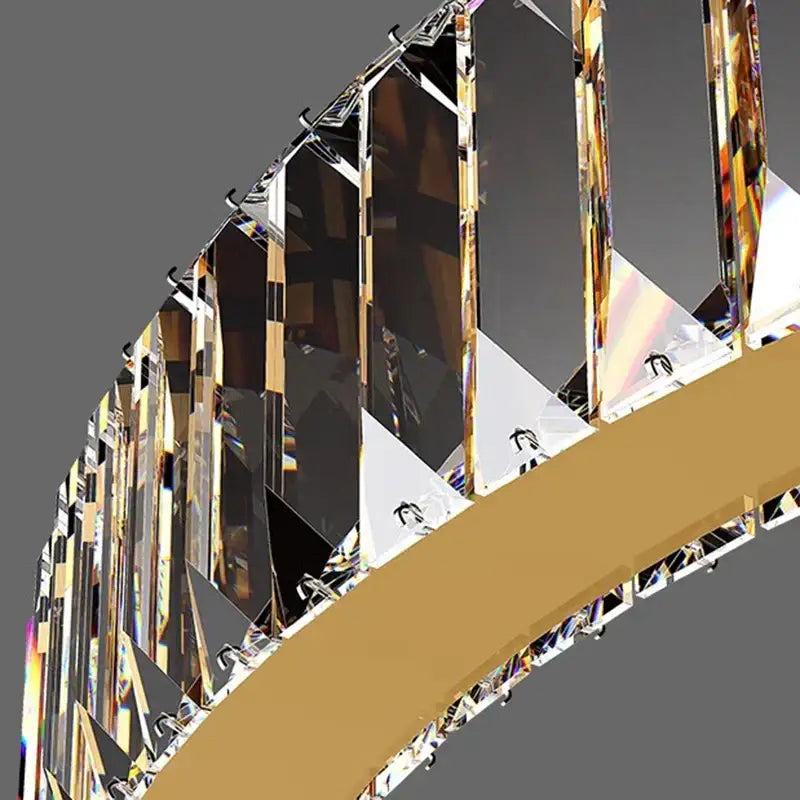 A modern decorbites crystal chandelier with curved design, faceted crystal prisms, and gold-toned metal accents