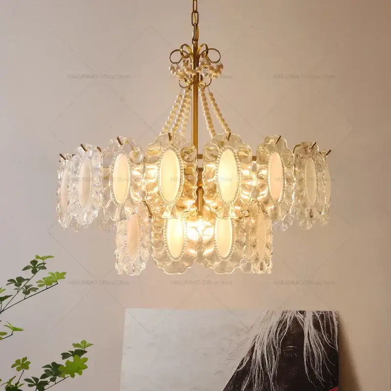 A decorbites crystal chandelier with clear crystal petals and gold-toned metal accents for modern luxury living rooms and bedrooms