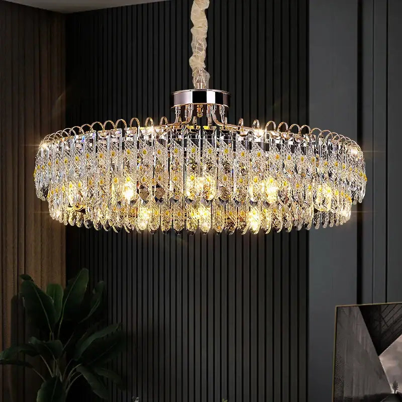 A decorbites crystal chandelier with polished chrome frame and cascading clear droplets illuminated by warm golden lights