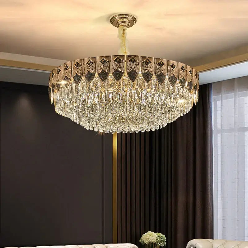 A gold-toned decorbites crystal chandelier with intricate geometric patterns and cascading clear droplets for modern luxury