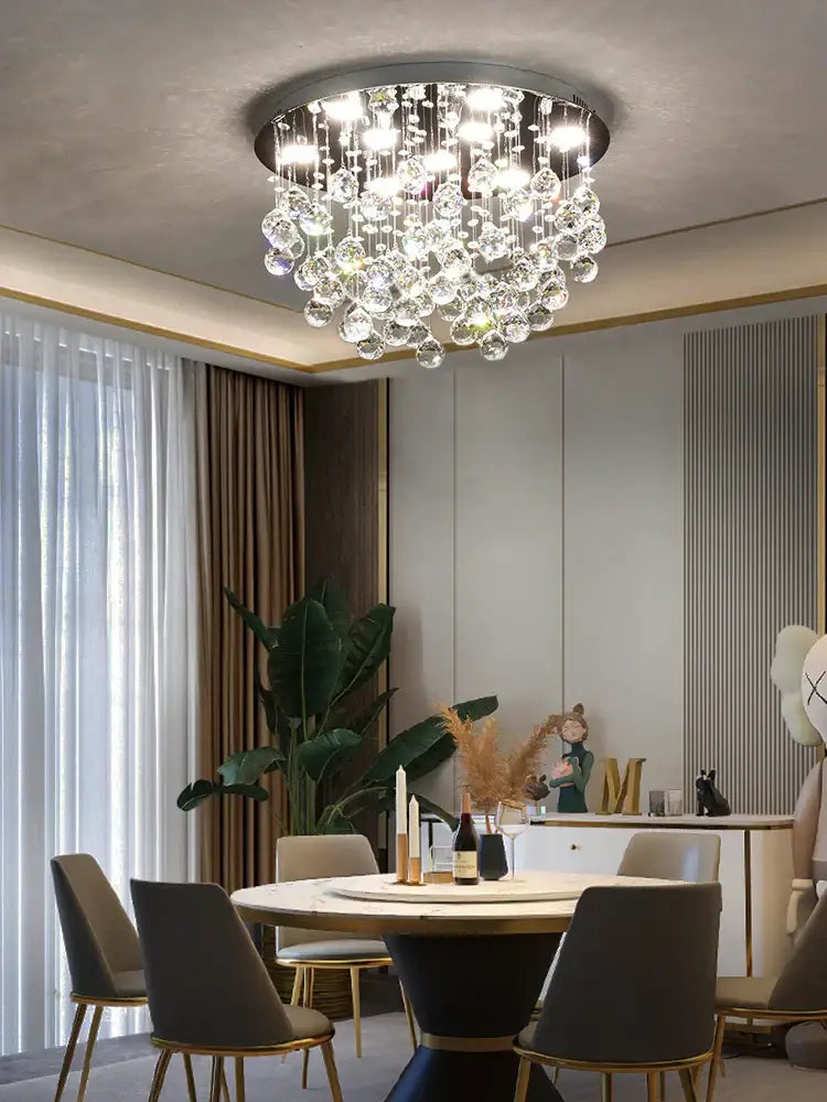 A modern decorbites crystal chandelier with a circular metal frame and cascading clear glass droplets for living rooms