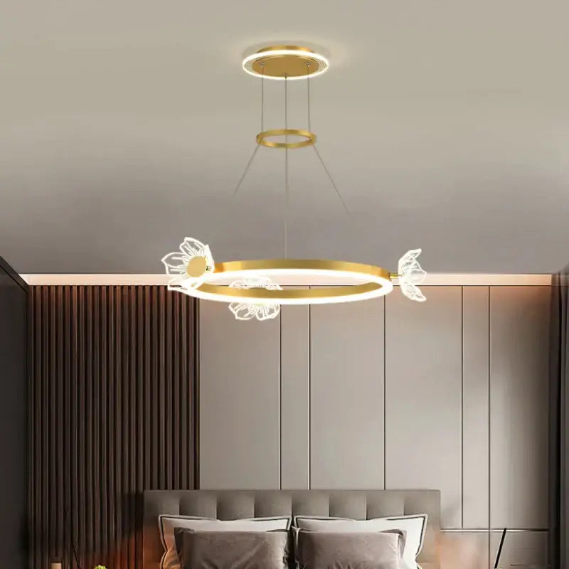 Gold-toned decorbites crystal chandelier with illuminated butterfly and flower accents for modern luxury lighting