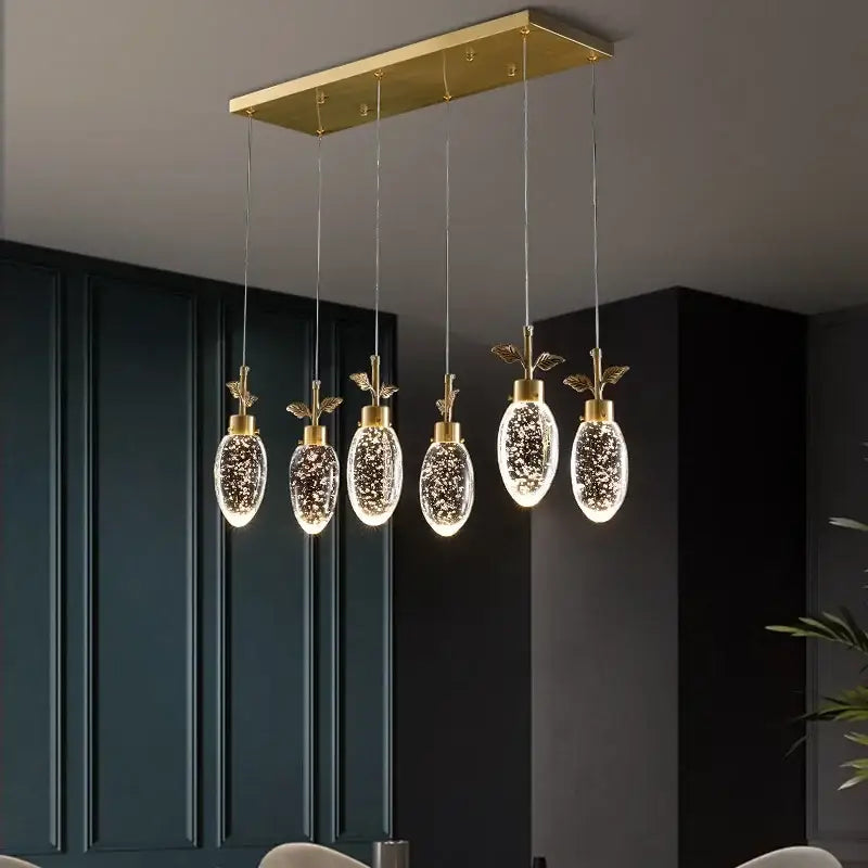 Gold-toned decorbites crystal chandelier with five oval glass pendants featuring sparkling glitter and gold leaf accents