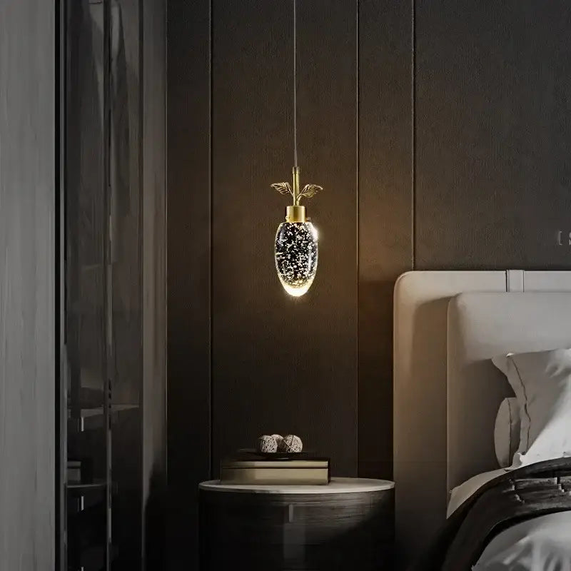 Gold-toned DecorBites crystal chandelier with sparkling oval crystal body and leaf-like top accent for modern luxury lighting
