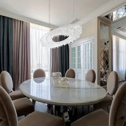 A decorbites crystal chandelier with sleek modern design and dazzling crystals hangs above a dining table