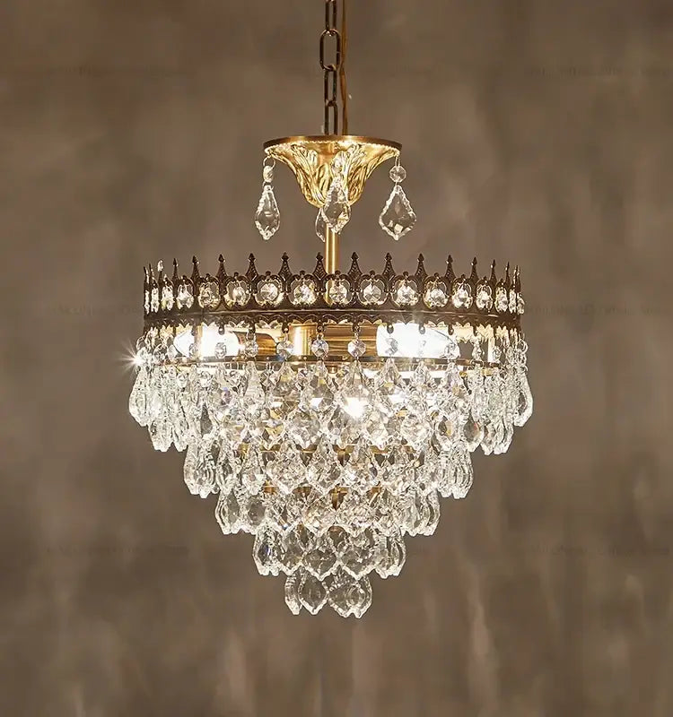 A decorbites crystal chandelier with tiered clear faceted crystals and a gold-toned metal frame for luxury lighting