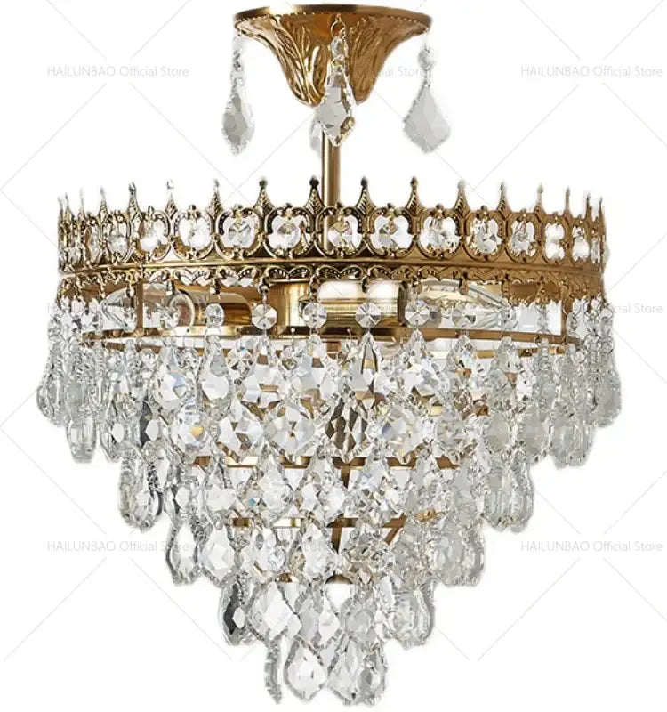 Gold-toned decorbites crystal chandelier with intricate crown detailing and cascading clear faceted crystal droplets