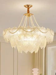 Elegant gold-toned decorbites crystal chandelier with layered glass leaf shades and beaded chains for luxury lighting