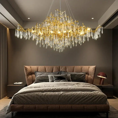 Golden decorbites crystal chandelier with crystal droplets hanging above the bed for modern luxury lighting