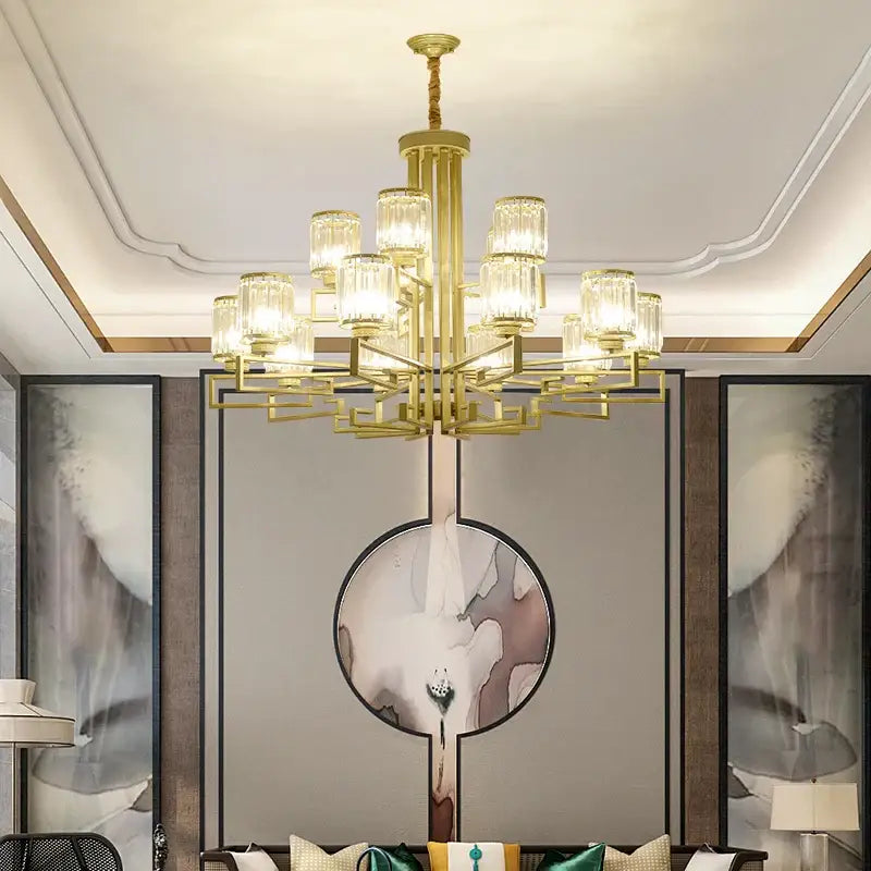 Gold-toned decorbites crystal chandelier with cylindrical glass shades in a geometric multi-tiered design for modern luxury lighting