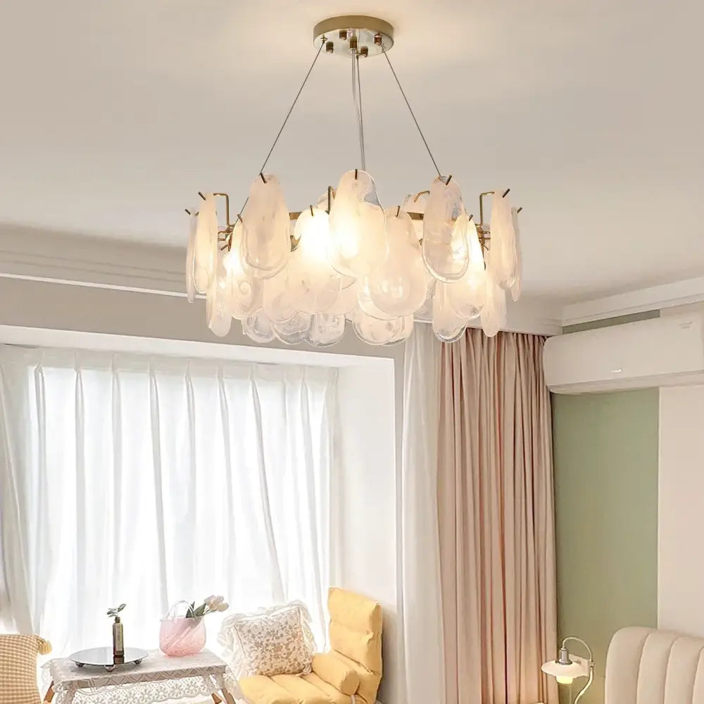 A modern decorbites crystal chandelier with frosted glass petals and brass fixture for luxury living spaces