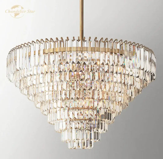 Decorbites crystal chandelier featuring a multi-tiered brass finish with cascading faceted clear crystals refracting light