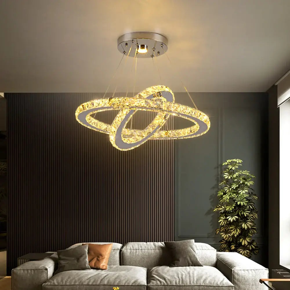 A decorbites crystal chandelier pendant lamp with gold-toned crystal rings and chrome mount for dining room and bedroom