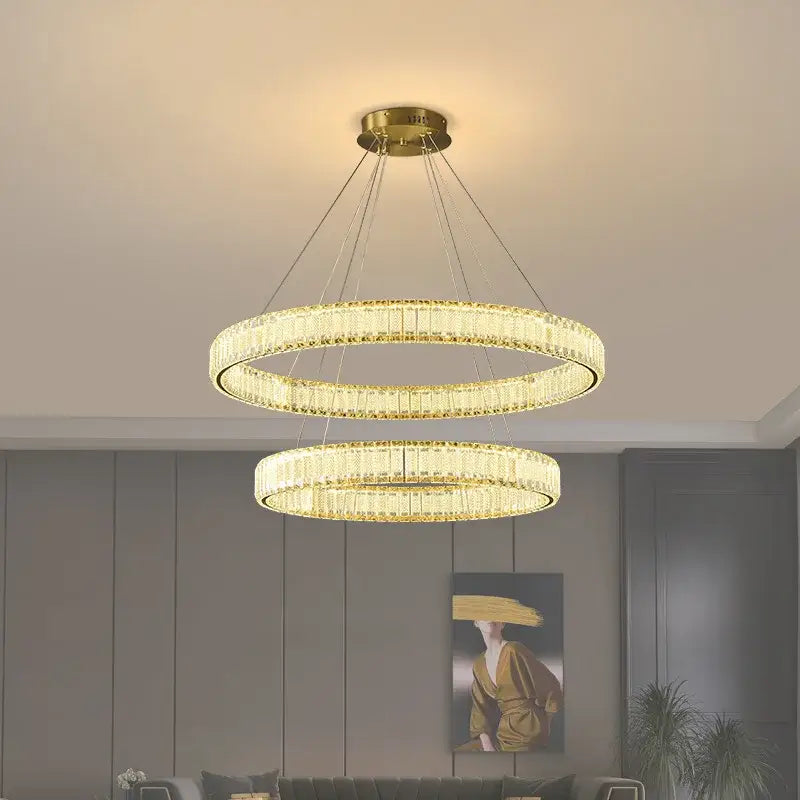 Gold-toned decorbites crystal chandelier featuring double crystal-encrusted rings for modern living room lighting