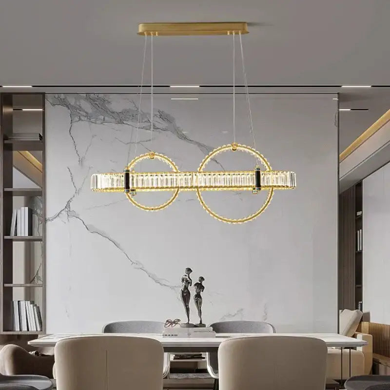 Gold-toned DecorBites crystal chandelier pendant light with two interlocking circular frames and clear crystal accents for living and dining rooms